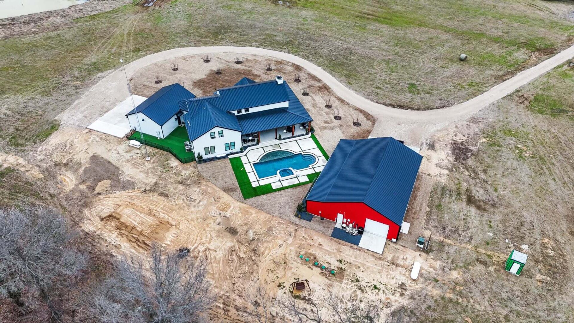 A group of houses with blue roofs and green grass.