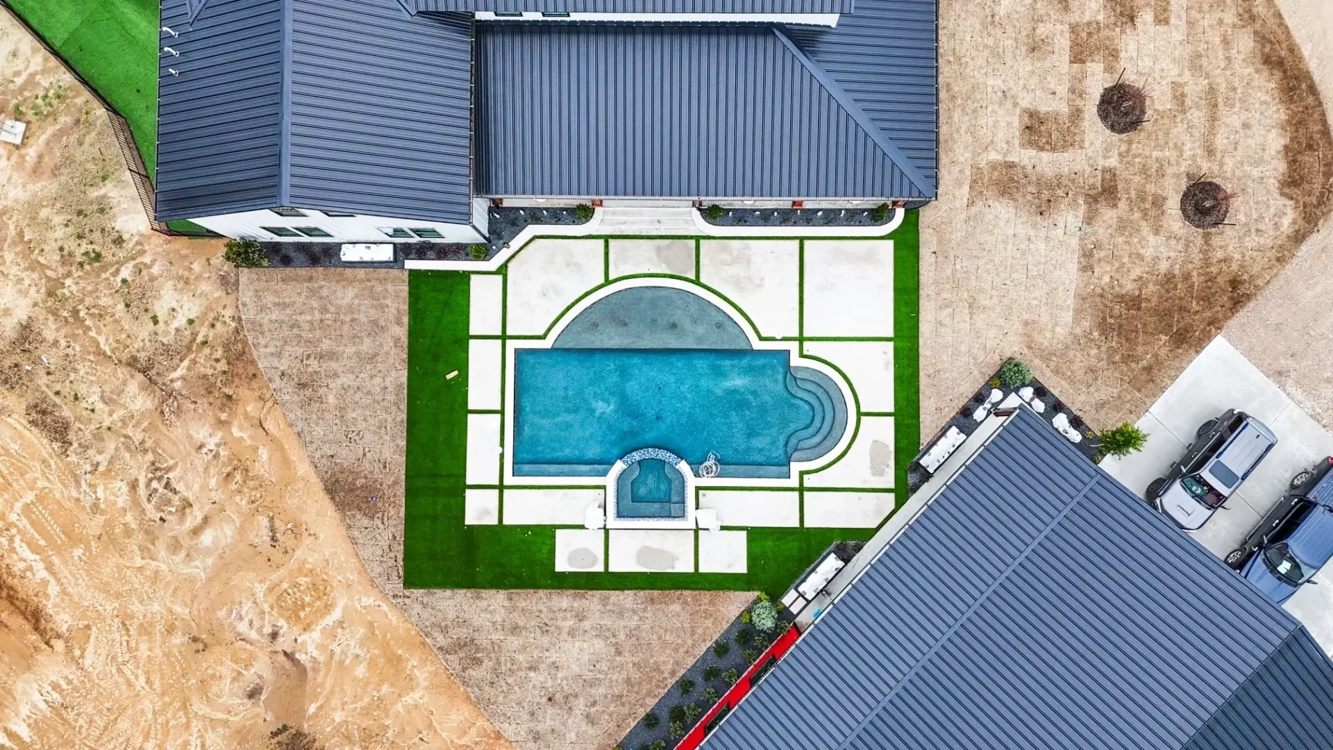 A pool with a blue tile roof and green grass.