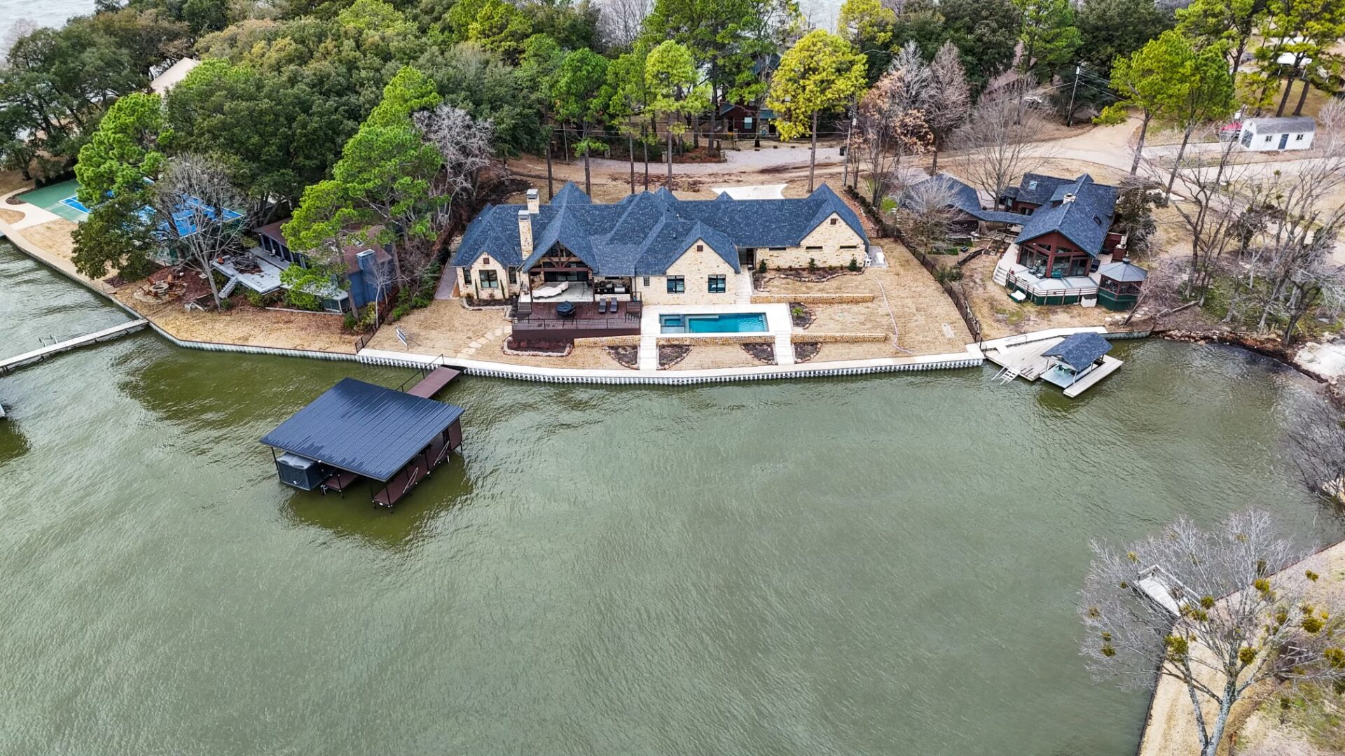 A house on the water with a dock and boat.